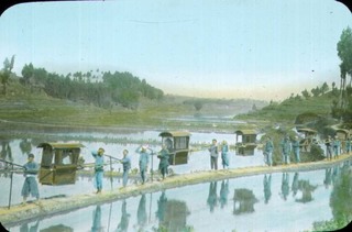 Procession of sedan chairs beside a river Credit: Best Family.